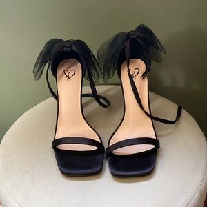 Strappy black heels with bow on back, size 7.5. Never worn